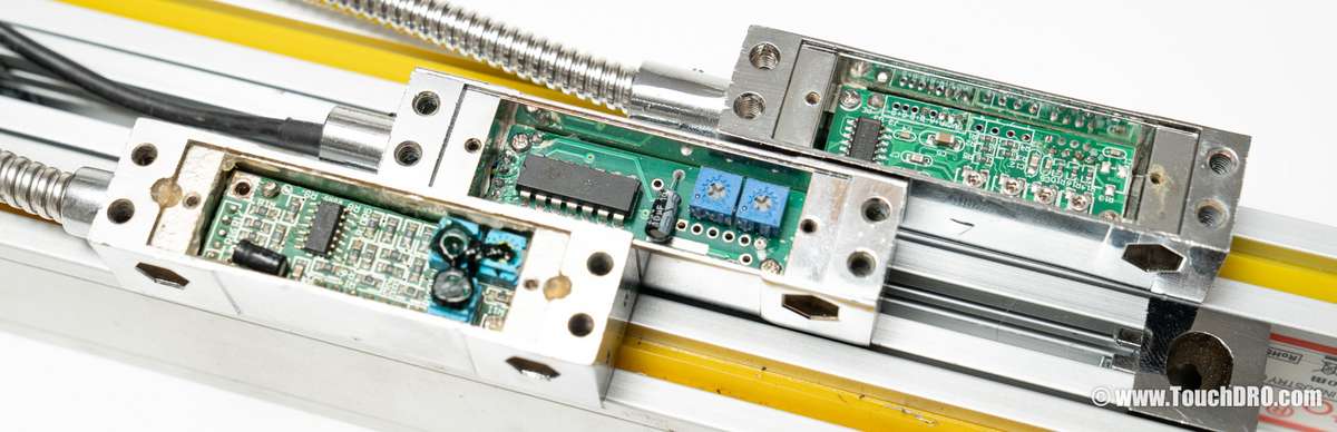 Internal PCBs of three common DRO scales, showing the output driver ICs used for quadrature signal generation