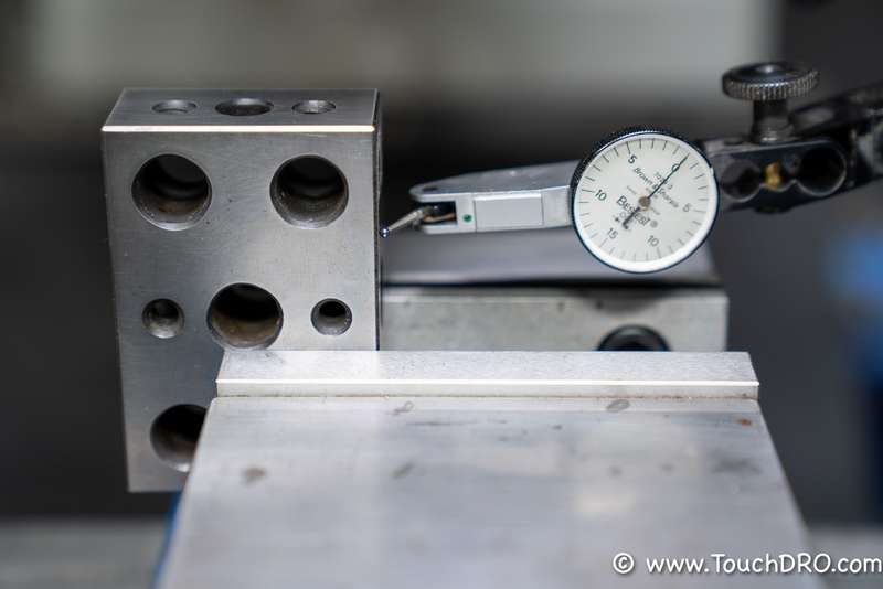 The indicator preloaded against the block's face Tenths test indicator preloaded against the face of a 1-2-3 block during a DRO accuracy check